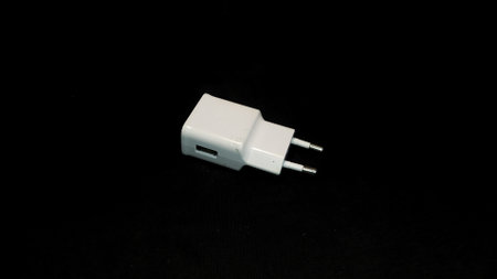 White charger adapter isolated on black backgroundの写真素材