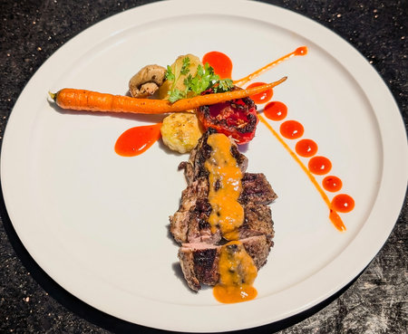 A stunning presentation of sliced beef steak, likely tenderloin, showing a desirable medium-rare interior and a charred exterior, elegantly topped with a rich orange-brown sauce.の写真素材