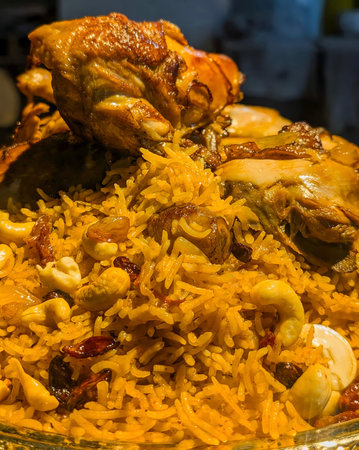 A generous, elevated serving of authentic Middle Eastern Mandi rice, featuring long-grain basmati rice seasoned with saffron and spices, topped with tender roasted chicken pieces, cashew nuts.の写真素材