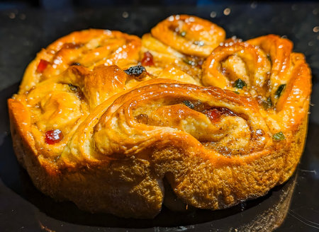 A golden, glazed cinnamon raisin bread twist displayed on a white plate, highlighting its rich...