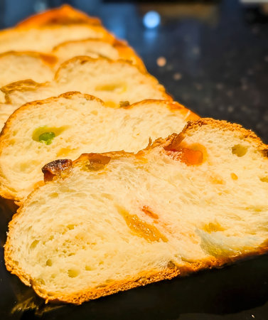 Six slices of golden-brown braided sweet bread featuring a soft, fluffy interior and colorful...