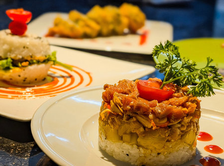 Elegant sushi-style stack featuring layers of white rice, diced mango, and finely chopped salmon with sesame.の写真素材