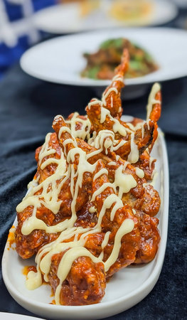 Crispy chicken wings glazed in spicy barbecue sauce and drizzled with creamy white dressing,...