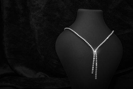 A luxurious and sophisticated diamond necklace elegantly displayed on a black velvet background. This necklace features a stunning Y-shaped design with sparkling diamonds, perfect for formal events or as a timeless gift for special occasions.の写真素材
