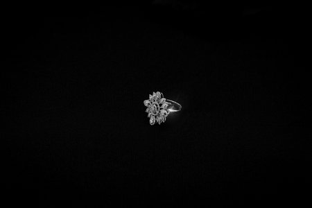 A stunning white gold diamond ring placed on a black velvet surface, showcasing its intricate design...