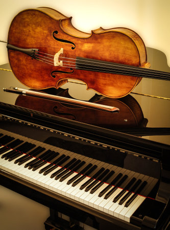 Cello and bow on grand piano with cream background