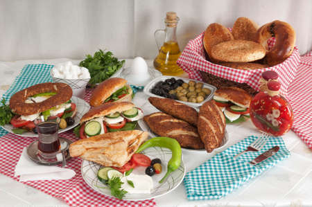 Breakfast consisting of olives, cheese, tomatoes, peppers and sandwiches