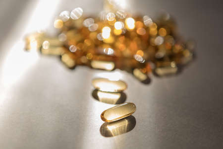 Vitamins pills of yellow color isolated on white background. Cod liver oil. Fish oil capsule pills...