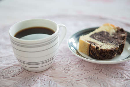 A cup of instant coffee and a slice of  homemade chocolate cake on old cloth napkinの写真素材
