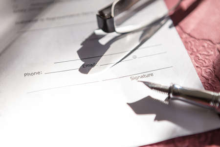 Close-up of Contract form with fountain pen and glassesの写真素材