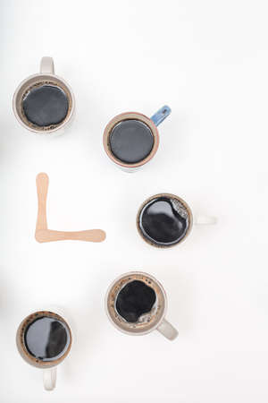 Half Clock made of  cups of coffee on white background with copy spaceの写真素材