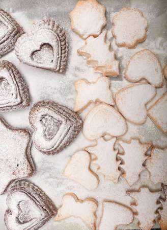 Close up freshly baked different shapes  new year cookies on snowy background,  top view