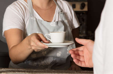 A waitress serving coffee , close up handsの写真素材