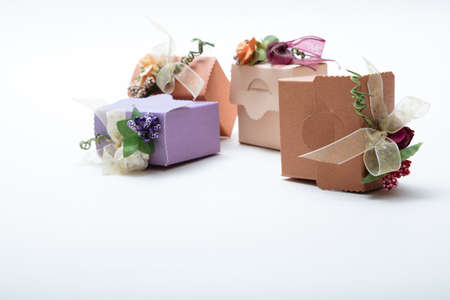 Close up view of special kind gift boxes with ribbon and flowers on white backgroung