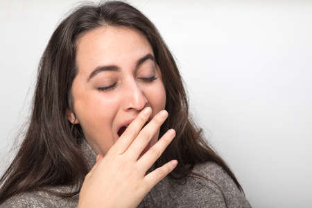 Series of four portraits of a beautiful woman yawning isolated on white with copy spaceの写真素材