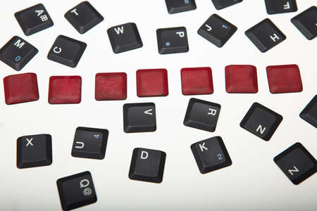 Overhead view of a composed  alphanumeric computer keyboard with seven blank red keys on silver gradient to white with copy space aboveの写真素材