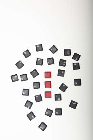 Overhead view of a composed  alphanumeric computer keyboard with three blank red keys on silver gradient to white with copy space aboveの写真素材