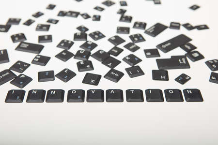 Computer keyboard composed of loose key covers from a computer with the word Innovation and digits in a close up high angle conceptual viewの写真素材