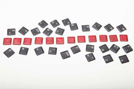 Overhead view of a composed  alphanumeric computer keyboard with twelve blank red keys on silver gradient to white with copy space aboveの写真素材