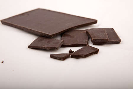 Dark milk chocolate bars stack isolated on a gray background, with copy space, viewed from high...
