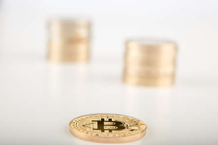 Stack of bitcoins with bitcoins background with a single coin facing the camera in sharp focus with...