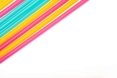 Top view of drinking straws colorful plastic tubes over white as abstract background with copy space