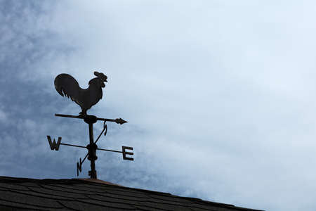 A weather vane, wind vane, or weathercock is an instrument for showing the direction of the wind. It is typically used as an architectural ornament to the highest point of a building.の写真素材
