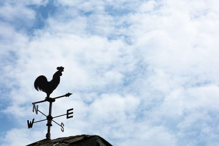 A weather vane, wind vane, or weathercock is an instrument for showing the direction of the wind. It is typically used as an architectural ornament to the highest point of a building.の写真素材