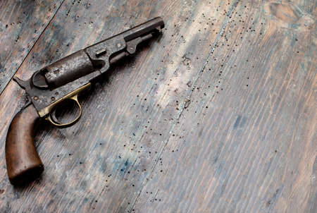 Vintage pistol on old wooden background with space for text.  Full frame high resolution image