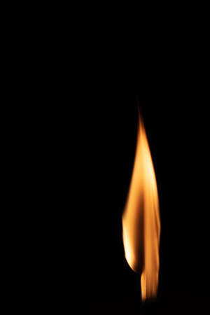 Match with strongly flaring flame on a black background closeupの写真素材