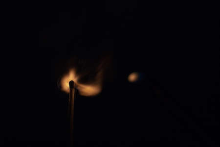 Match with strongly flaring flame on a black background closeupの写真素材