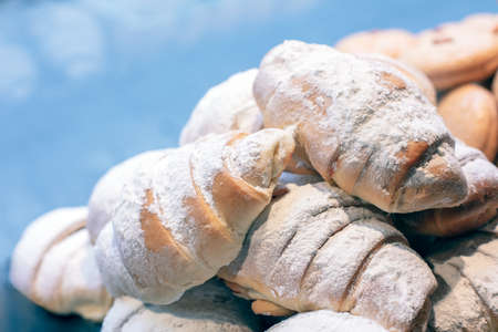 Croissants sprinkled with powdered sugar isolated on a blue background closeupの写真素材