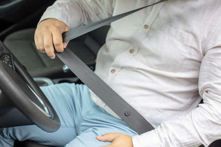 Business man  sitting on car seat and fastening seat belt, car safety concept.の写真素材