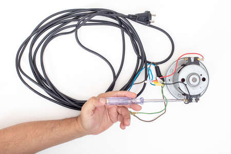 Vacuum cleaner motor  with cord and srewdriver on a white background top viewの写真素材