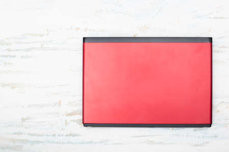 Red laptop computer isolated on white wooden background, top view with copy spaceの写真素材