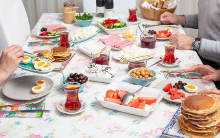 Turkish breakfast with simit, pancake, cheese, cherry , tomato, cucumber, and tea on a table high angle view, selective focusの写真素材