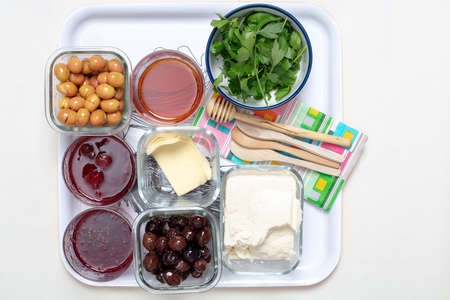Traditional Turkish  breakfast with olives, feta cheese,  parsley , honey and jam on a white tray...
