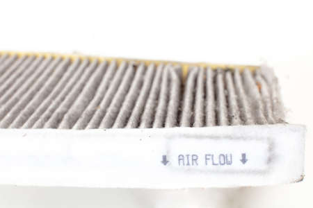 Changing a  car cabin pollen filter . High efficiety particle air filter.(Old one)  white background cutoutの写真素材