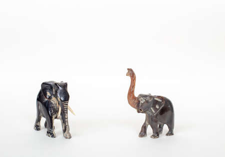 Two handmade Elephant figurine , one of them have long ivory  isolated on white with shadows