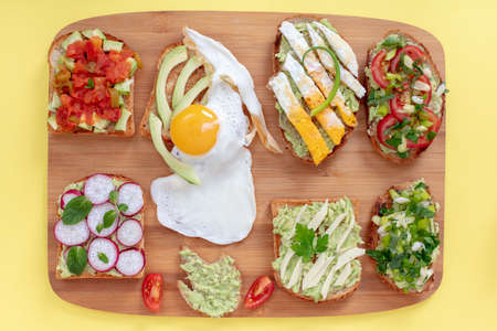 Variation of  healthy breakfast sandwiches  on toasted breads with avocado and different ingredients...