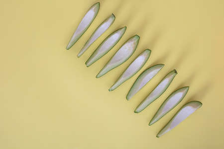 Avocado slices isolated on yellow background with shadows.の写真素材