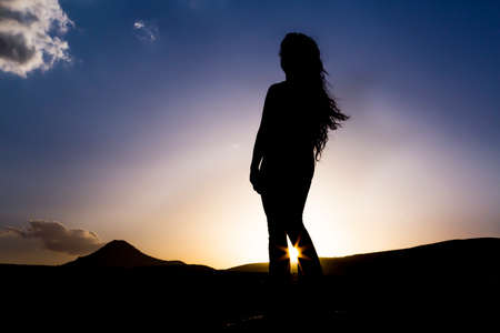 Girl silhouette at sunsetの写真素材