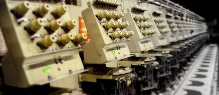 Textile - Professional and industrial embroidery machine. Machine embroidery is an embroidery process whereby a sewing machine or embroidery machine is used to create patterns on textiles.の写真素材