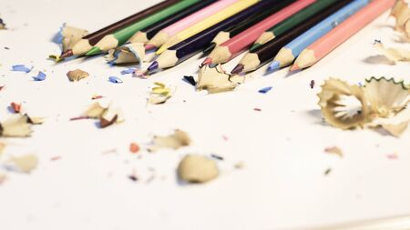 Close-Up Of Colored Pencils With Shavings Over White Background