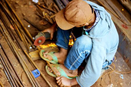 Bangladeshi young boy cutting metal at outside.Metal cutting selective focus with copy space for...