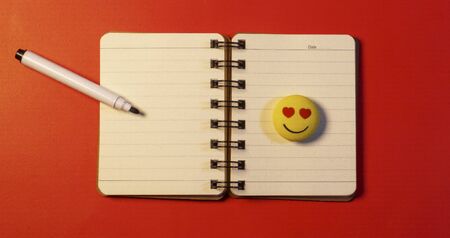 Dhaka,Bangladesh-March 13 , 2020 : Isometric open blank spiral notebook and white pen isolated on red background. Mock up for corporate identity and promotion objects.の写真素材