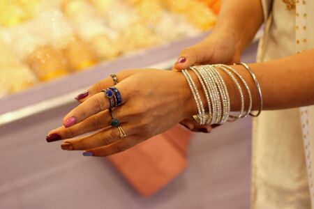 Hands of a woman trying to wear of bangles on her hand.Selective focus with copy space for text.の写真素材