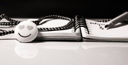Note book,White Pen,Love Emoji Business and Education concept with black and white background.Selective focus with copy space for text.の写真素材
