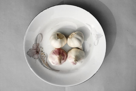 Garlic on a plate.Top view garlic with plate on a ash background.の写真素材