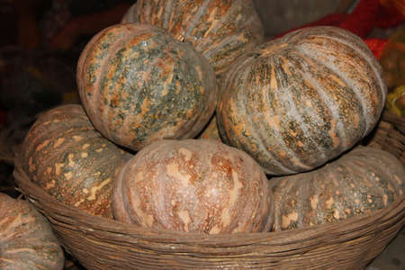 Heap of pumpkin on a big bamboo basket isolated on a black background.Pumpkin contains rich in vitamins,minerals and antioxidants.の写真素材